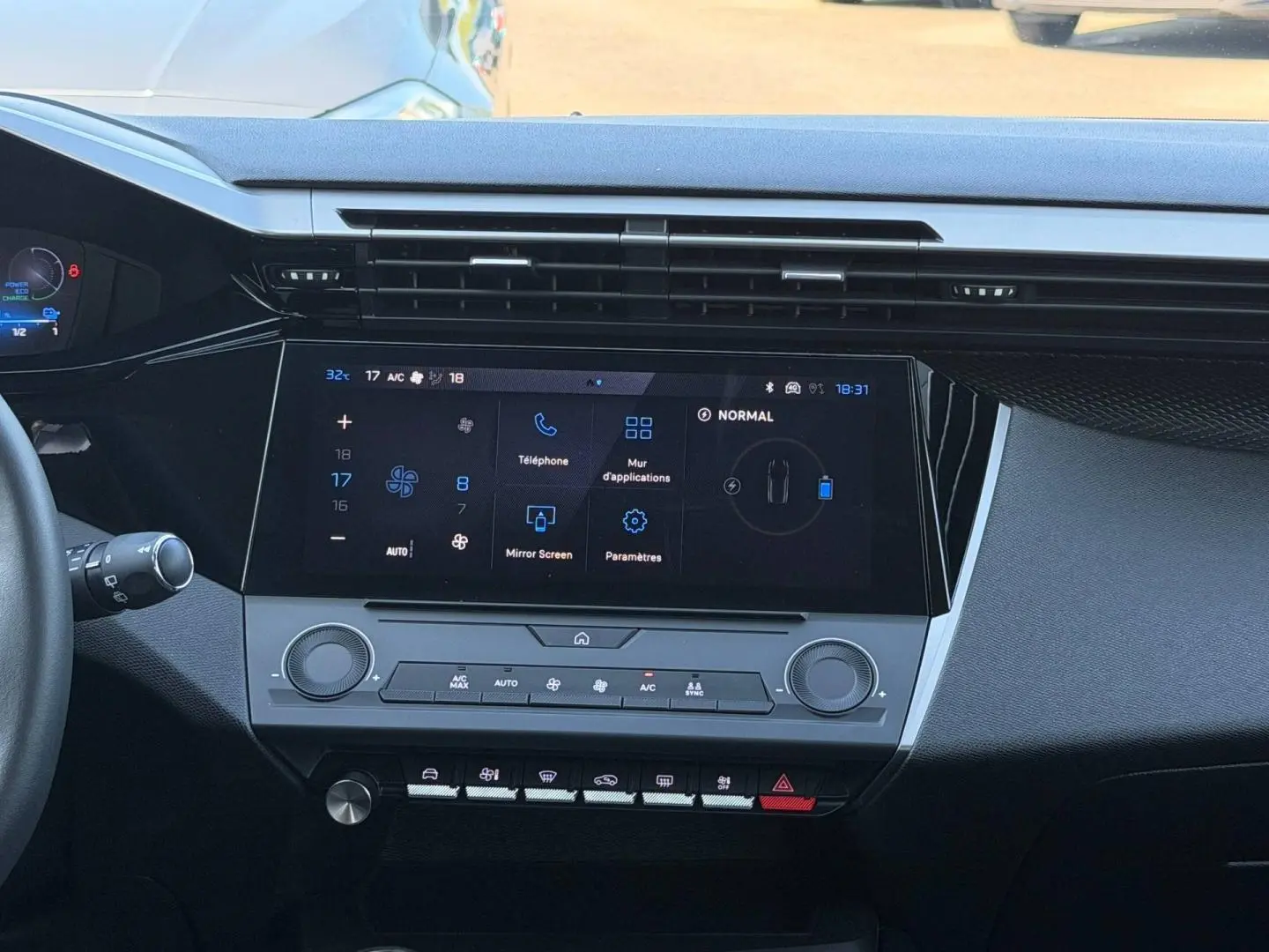 Vue intérieure centrée sur la console tactile et les commandes climatisation du Peugeot e-308 noir Perla Nera 2025.