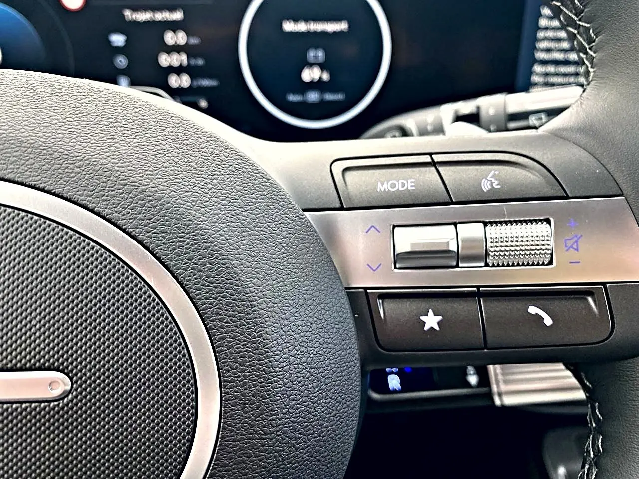 Gros plan sur le côté droit du volant cuir multifonction du Hyundai Kona gris, avec commandes audio et téléphone.