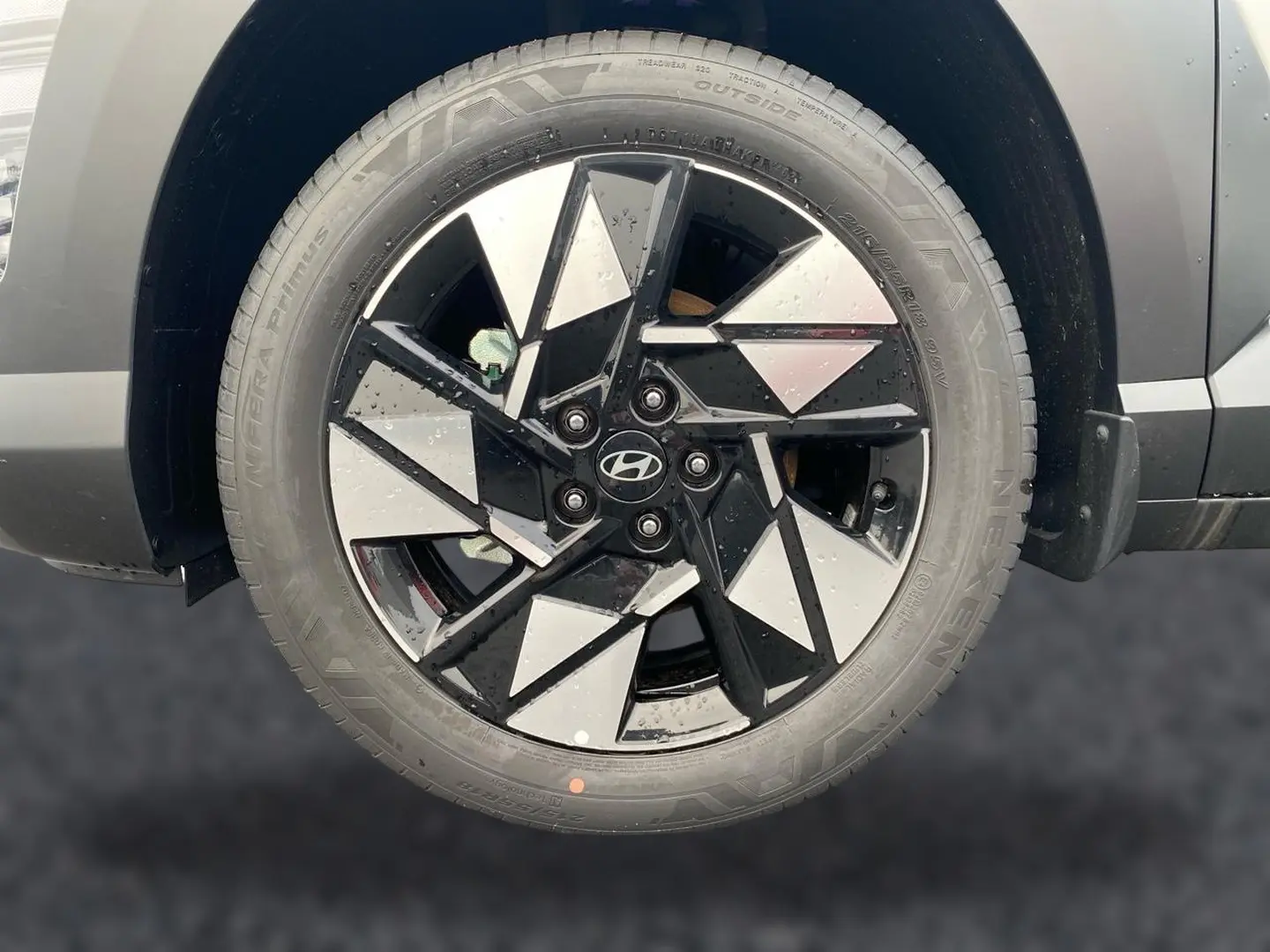 Gros plan sur la roue avant droite gris foncé du Hyundai Kona 2025 avec jante alliage noire et argentée au design géométrique.