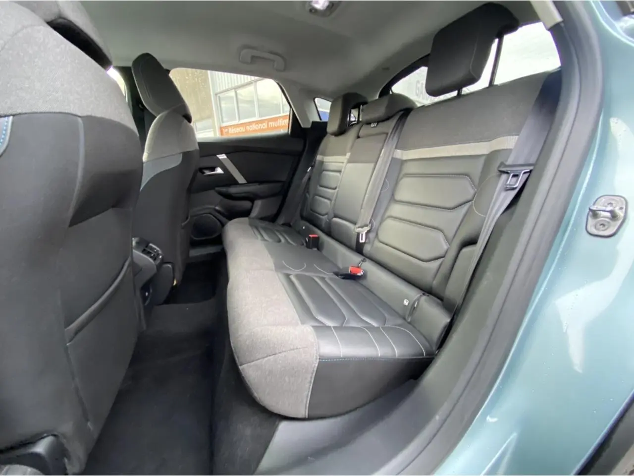 Vue intérieure arrière côté droit des sièges arrière en cuir et tissu du Citroën C4 Bleu Iceland 2021 berline Shine