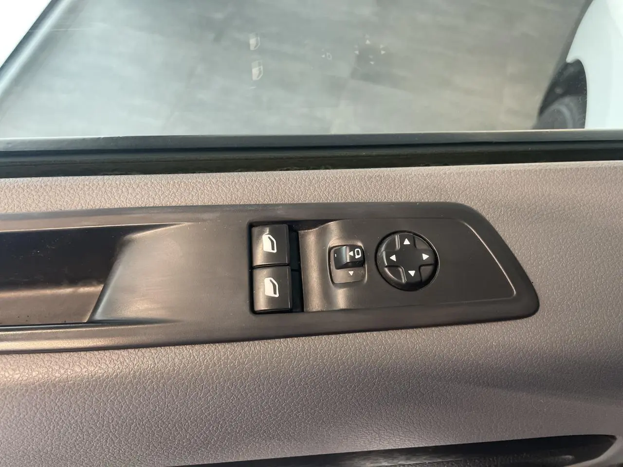 Commande des vitres et rétroviseurs sur la portière côté gauche d’un Opel Vivaro blanc 2021.