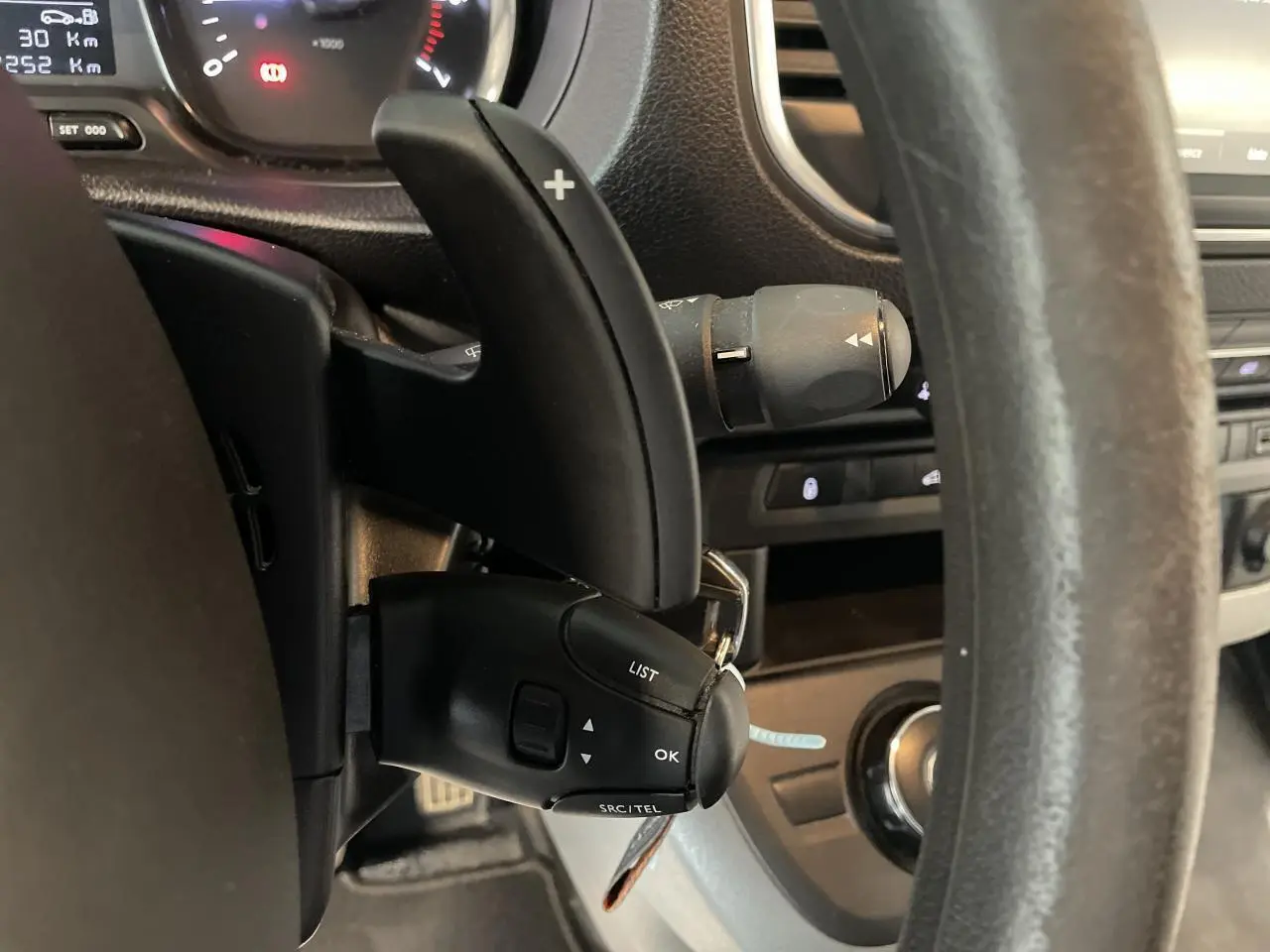 Gros plan sur le volant et commandes au volant du fourgon blanc Opel Vivaro 2021, avec palettes de changement de vitesse.