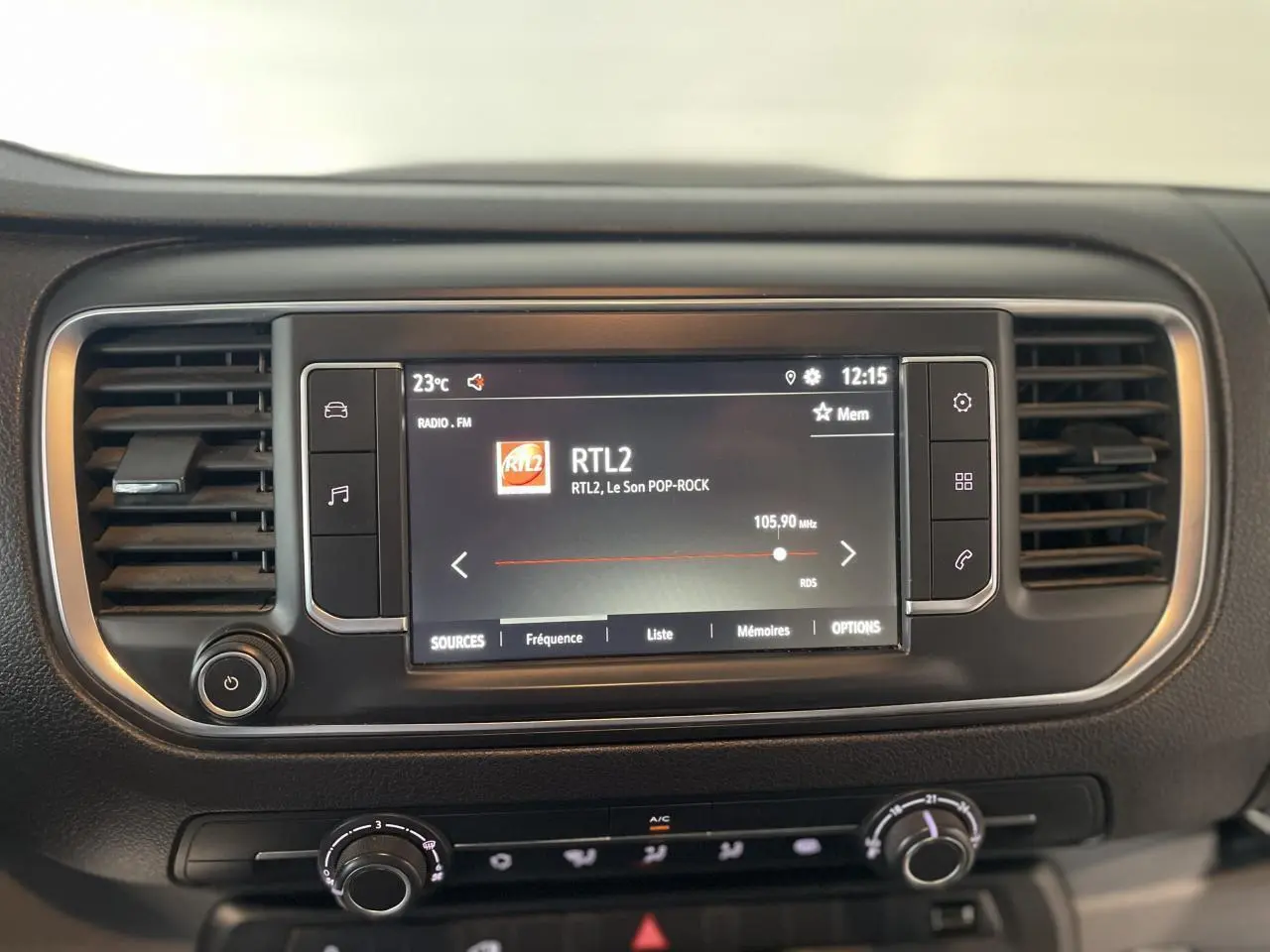 Tableau de bord noir de l'Opel Vivaro 2021 avec écran tactile radio affichant la station RTL2 à 12:15