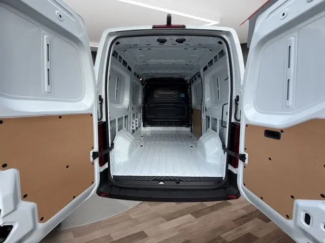 Vue arrière du Renault Master blanc 2025 avec portes arrière ouvertes montrant l'espace de chargement vide et tôlé.