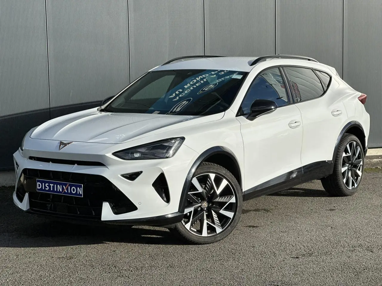 Vue 3/4 avant d'une CUPRA Formentor blanche avec jantes alliage noires et calandre marquée au logo CUPRA.