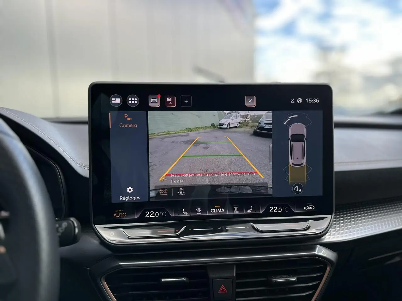 Écran tactile central du tableau de bord du CUPRA Formentor gris, affichant la caméra de recul et les réglages de climatisation.