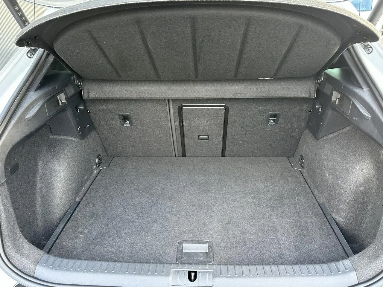 Coffre ouvert vu de l'arrière du CUPRA Formentor gris Magnétique, montrant l'espace de chargement et la trappe à skis.