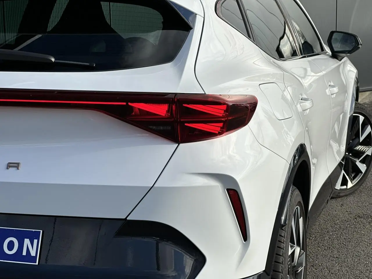 Vue 3/4 arrière droite d'une CUPRA Formentor blanche avec feux arrière LED et jantes alliage distinctives.