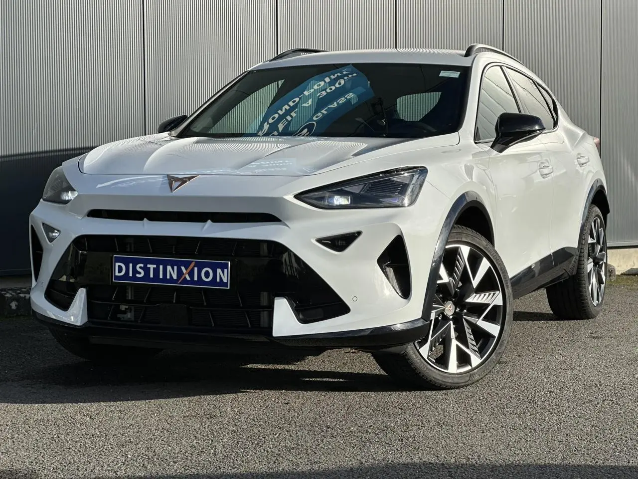 Vue 3/4 avant droite d'une CUPRA Formentor blanche avec jantes alliage noires et calandre marquée.