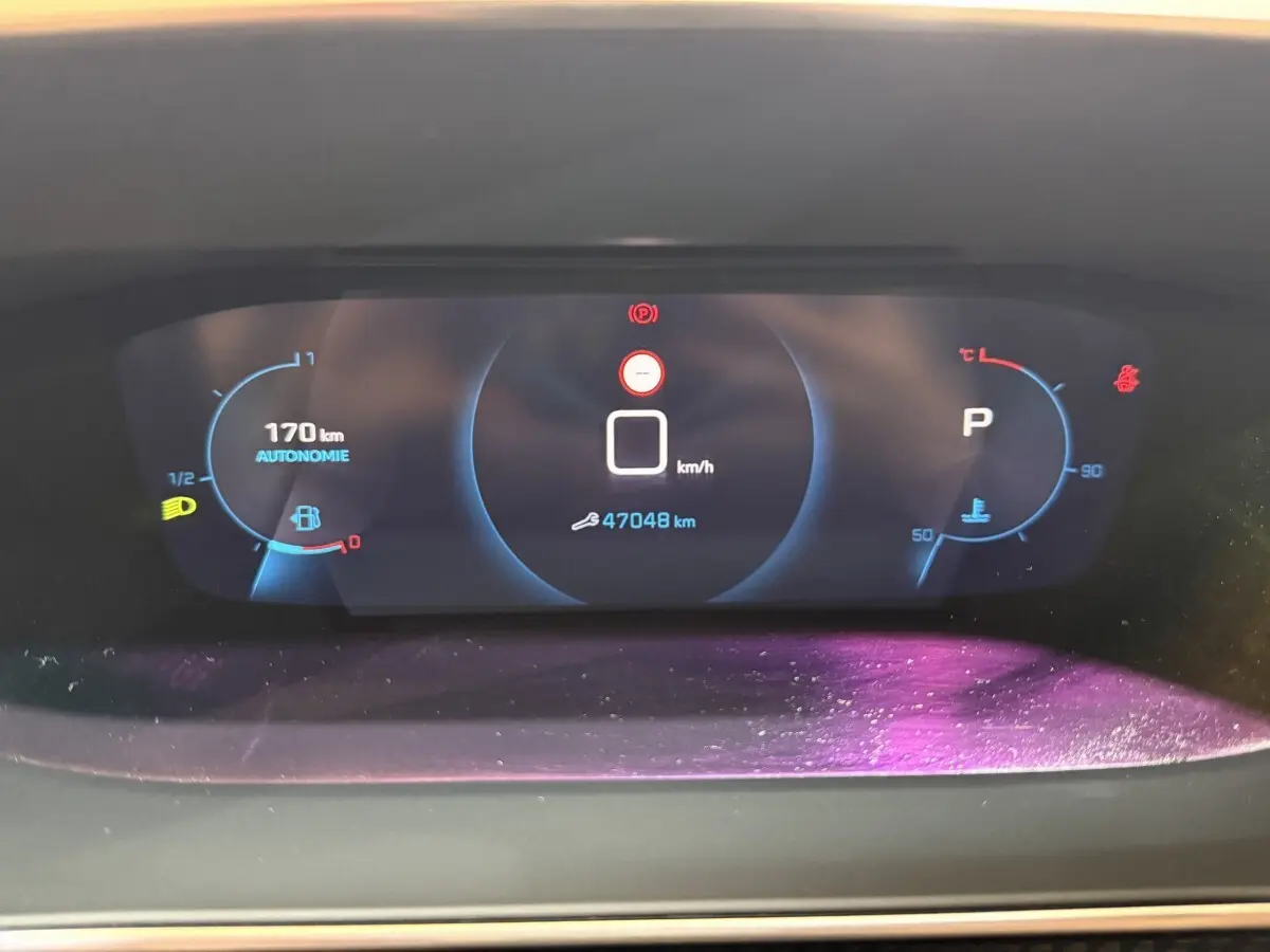 Tableau de bord numérique du Peugeot 2008 2023 affichant vitesse, autonomie et température moteur.