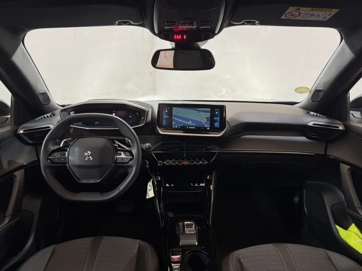 Vue intérieure avant du Peugeot 2008 gris clair 2023, tableau de bord avec écran tactile central et volant multifonctions cuir.