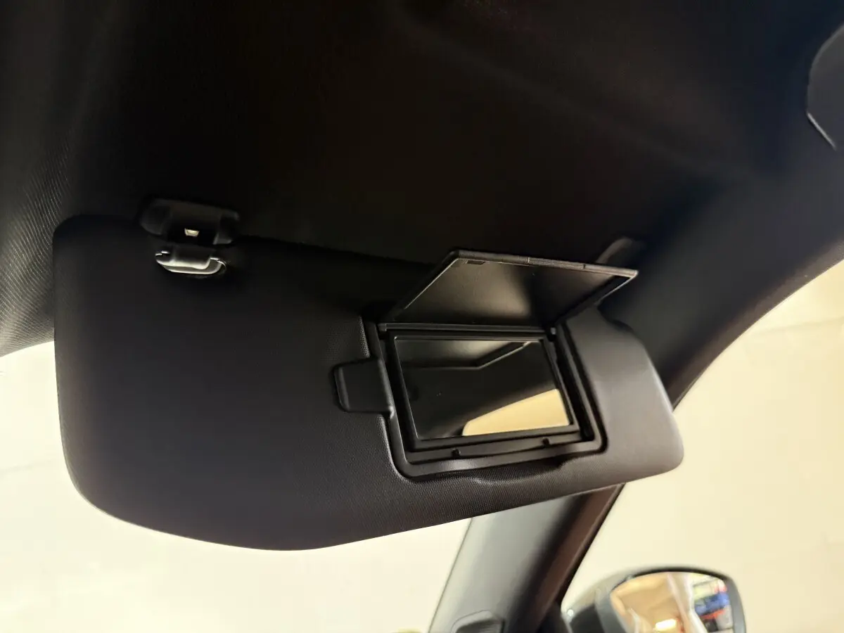 Miroir de courtoisie ouvert sur pare-soleil côté conducteur dans l’habitacle d’un Peugeot 2008 gris clair 2023.