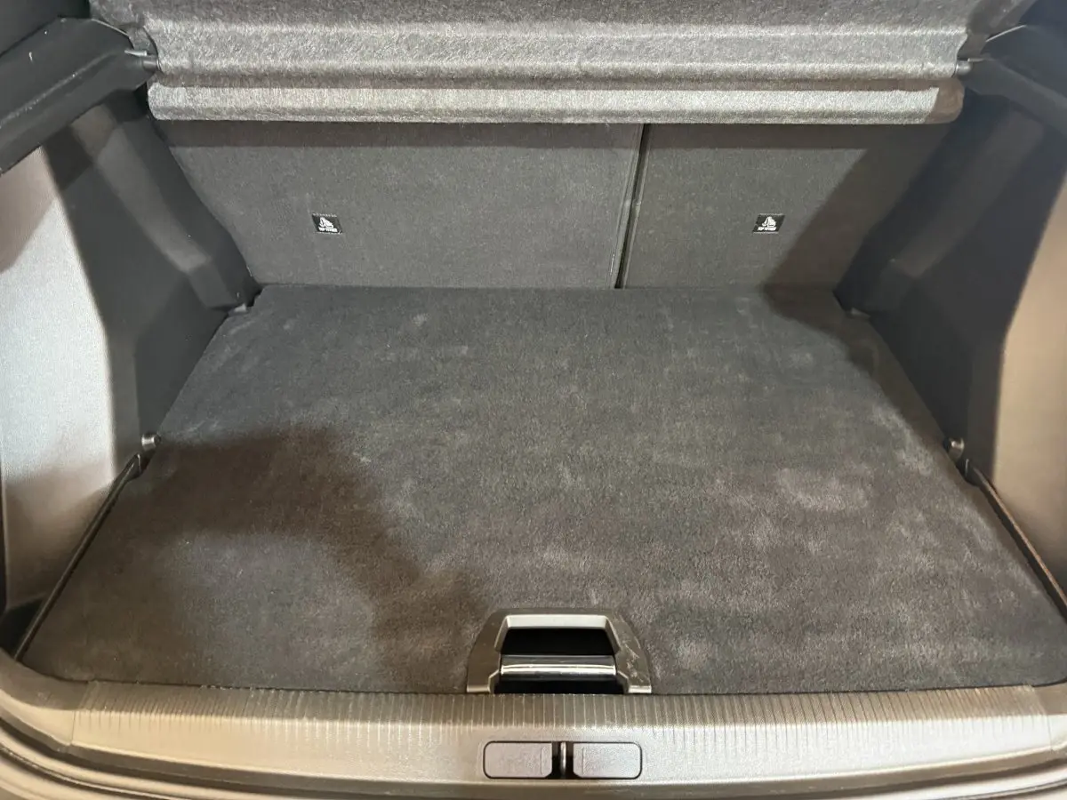Coffre vide en vue plongeante d'un Peugeot 2008 gris clair, soulignant l'espace de rangement et la tablette arrière.