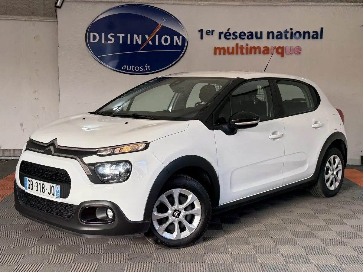 Vue 3/4 avant droite d'une Citroën C3 blanche 2021 avec phares LED et rétroviseurs noirs brillants.