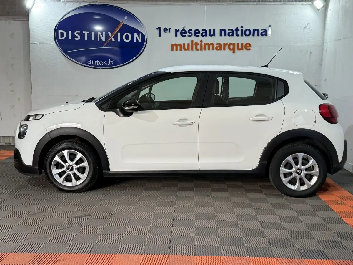 Profil droit d'une Citroën C3 blanche 2021 avec protections noires et jantes alliage en concession.