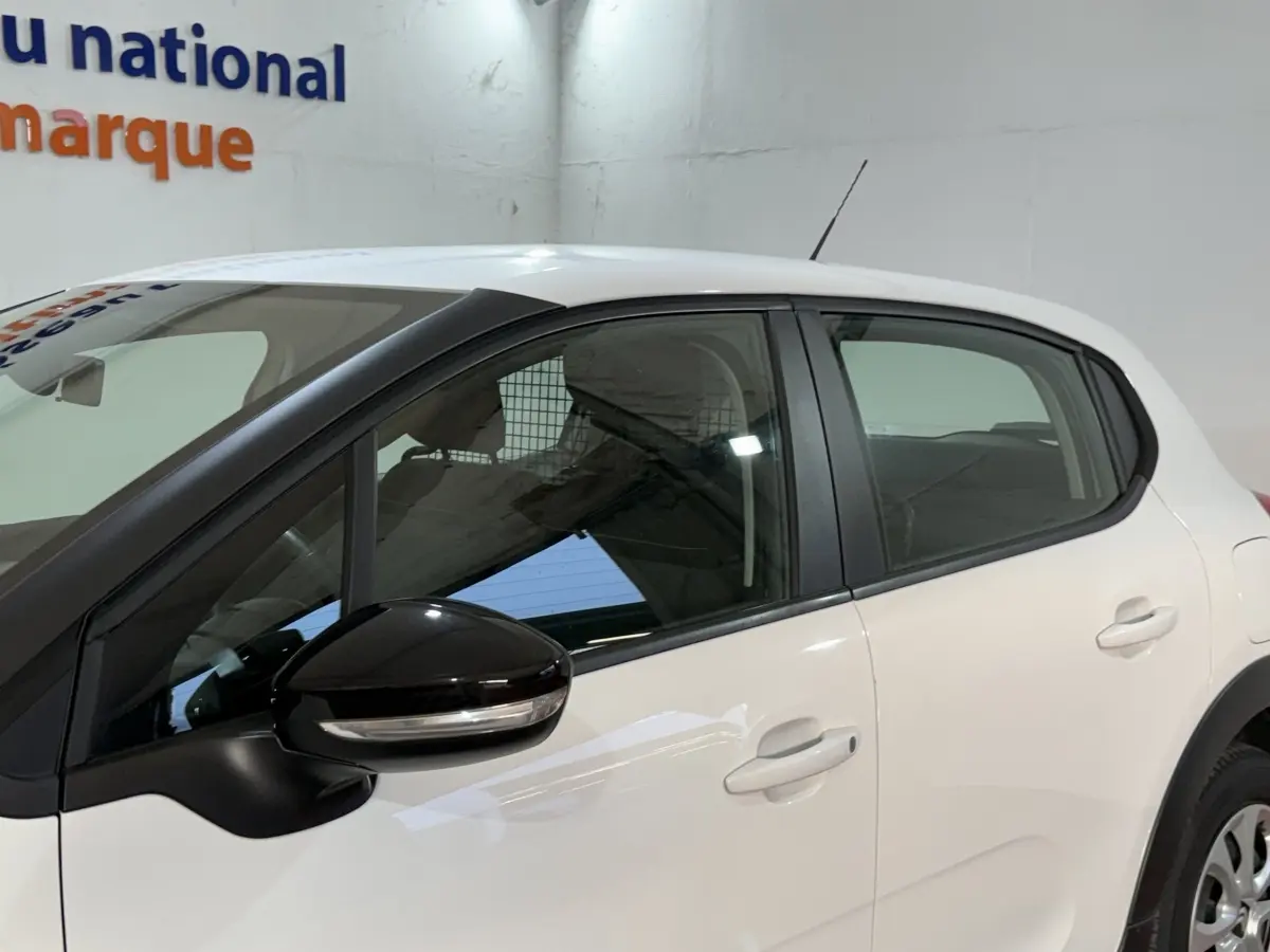 Vue latérale gauche d'une Citroën C3 blanche 2021 avec rétroviseur noir et poignées de porte assorties.