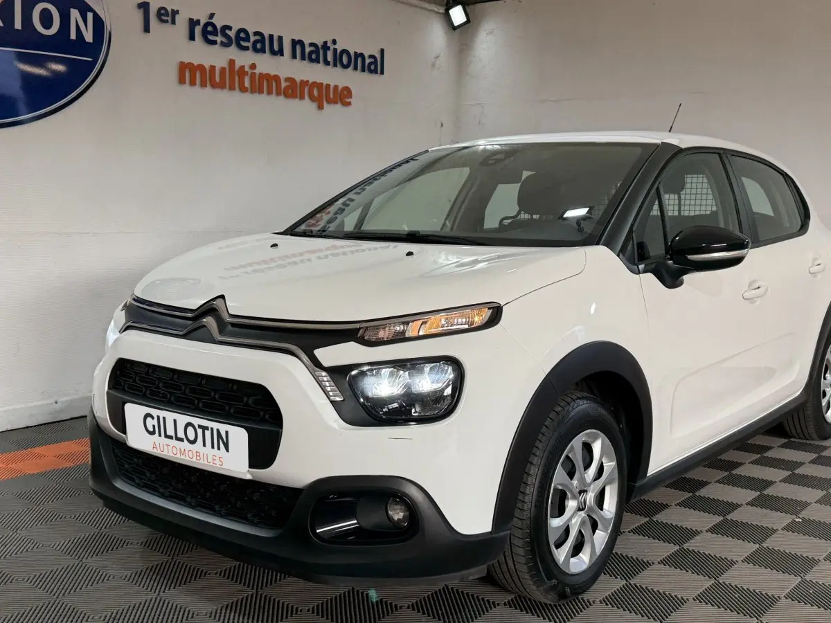 Citroën C3 blanche vue 3/4 avant droit, avec phares LED allumés et jantes alliage argentées.
