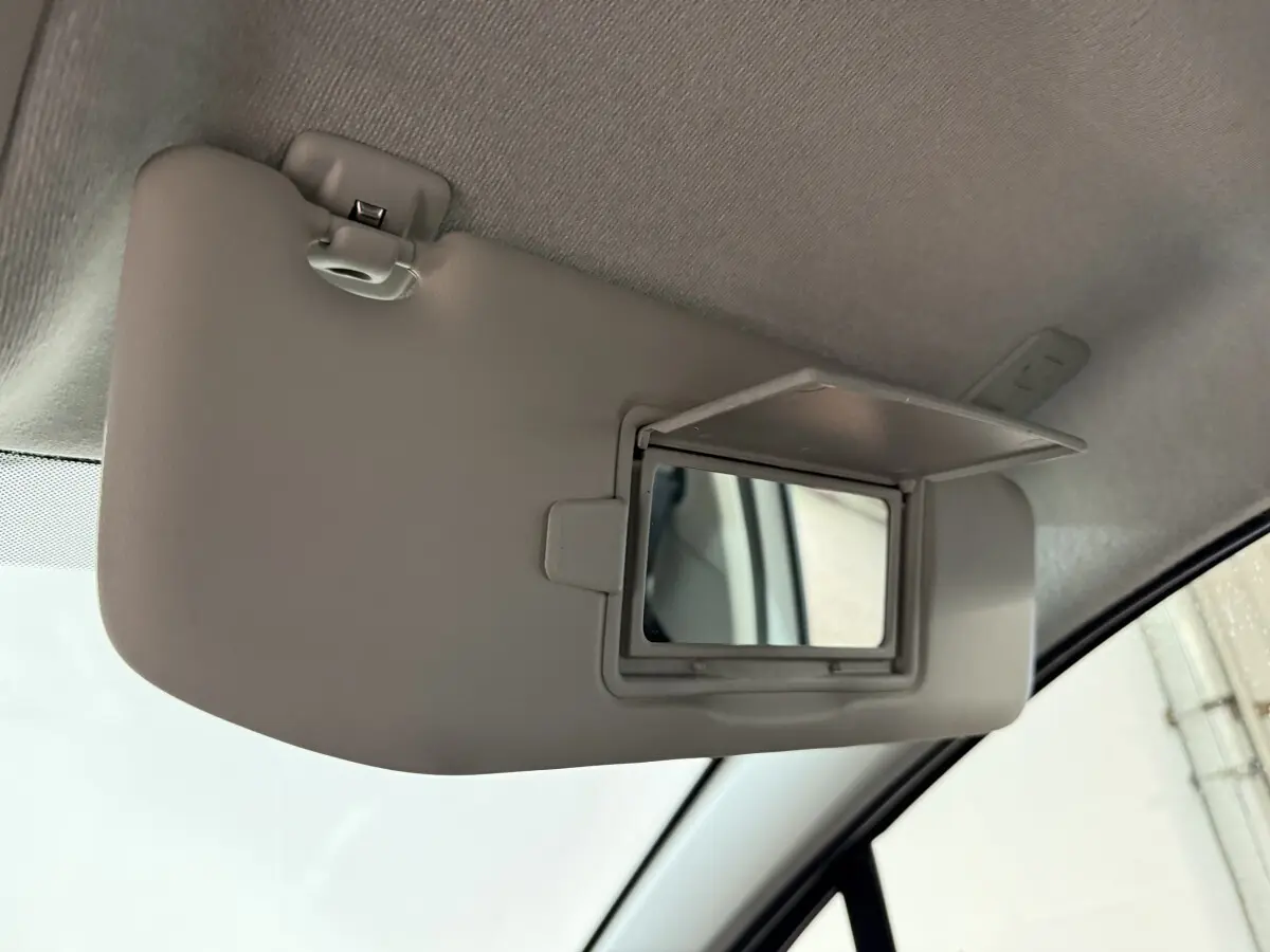 Détail du pare-soleil côté conducteur avec miroir de courtoisie ouvert dans une Citroën C3 blanche de 2021.