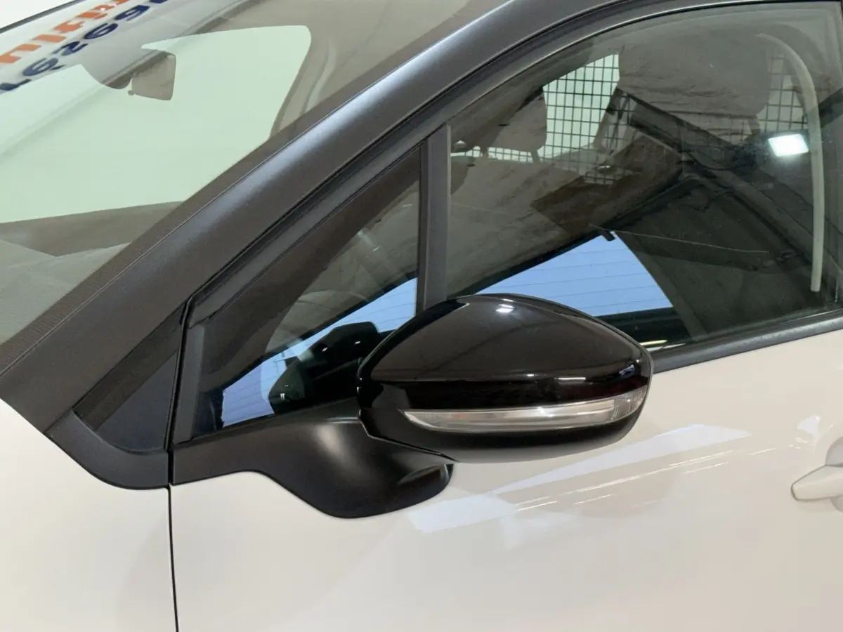 Gros plan sur le rétroviseur noir côté conducteur d’une Citroën C3 blanche, vue latérale gauche.