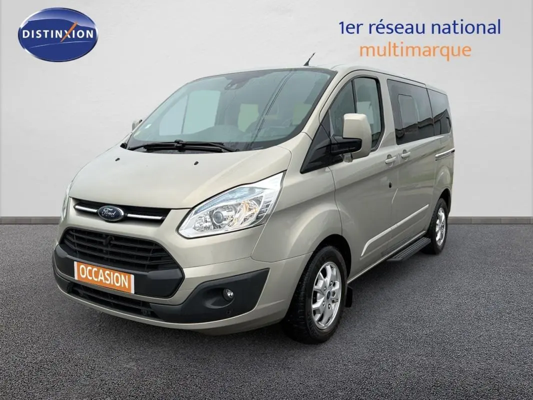 Vue 3/4 avant droit d'un Ford Tourneo Custom gris clair avec porte latérale et jantes alliage 16 pouces.