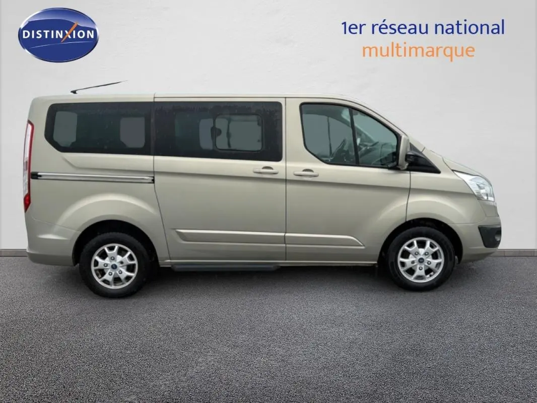 Vue latérale droite d’un Ford Tourneo Custom gris clair avec vitres surteintées et jantes alliage.