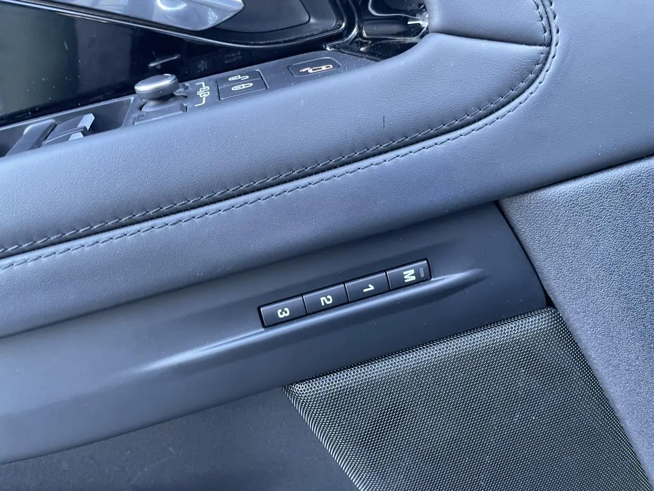 Détail des commandes de mémoire des sièges sur la portière intérieure en cuir noir du Range Rover Evoque gris.