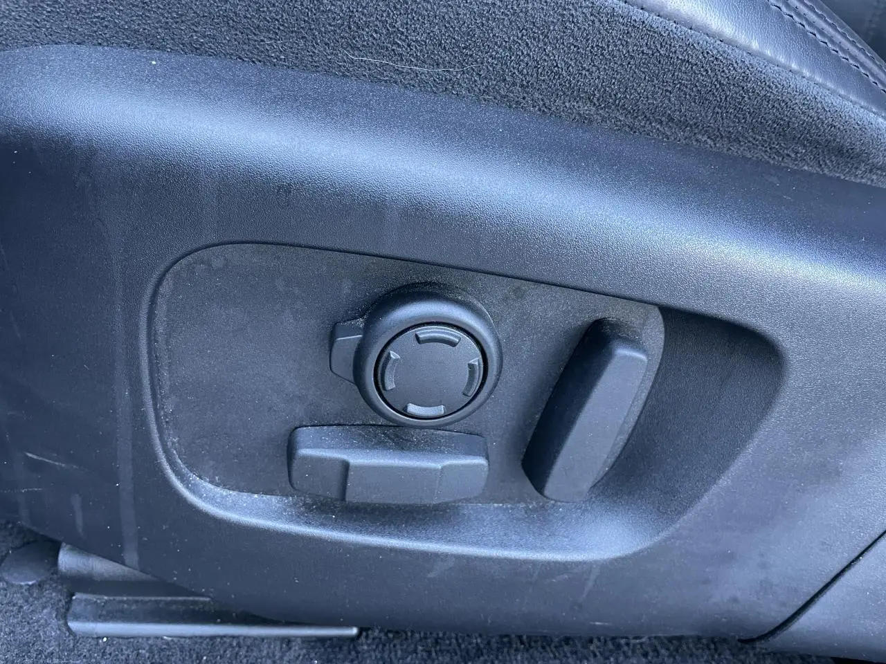 Gros plan sur les commandes de réglage électrique du siège avant droit du Range Rover Evoque gris 2019.