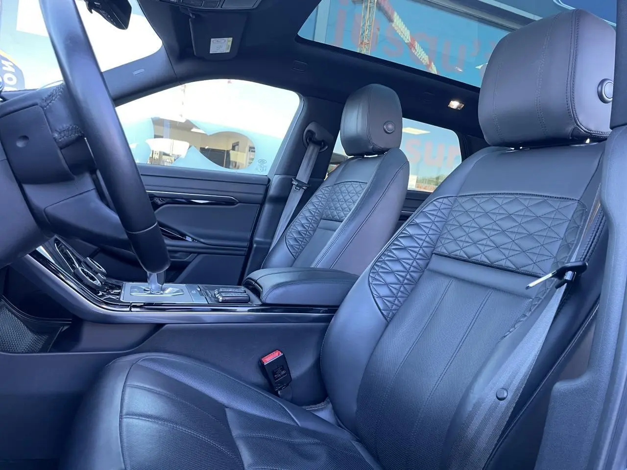 Intérieur cuir noir du Range Rover Evoque 2019, vue côté conducteur avec sièges avant et console centrale.