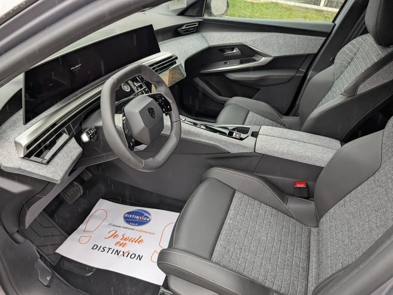 Intérieur avant droit du Peugeot 5008 2025 gris Artense, avec sellerie tissu gris et cuir noir et i-Cockpit panoramique.