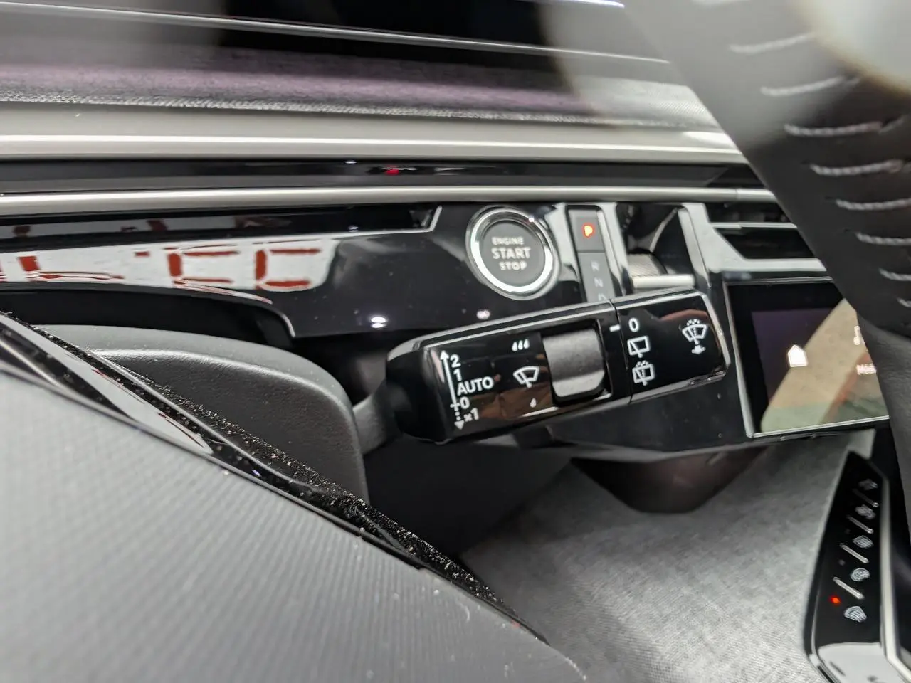 Gros plan sur la commande d’essuie-glace et bouton start du tableau de bord noir laqué du Peugeot 5008 Gris Artense.