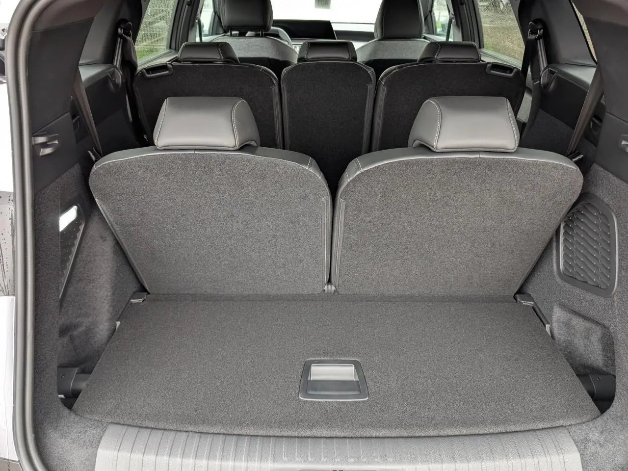 Coffre arrière du Peugeot 5008 gris Artense, vue intérieure montrant la banquette 3e rangée relevée et le plancher plat.