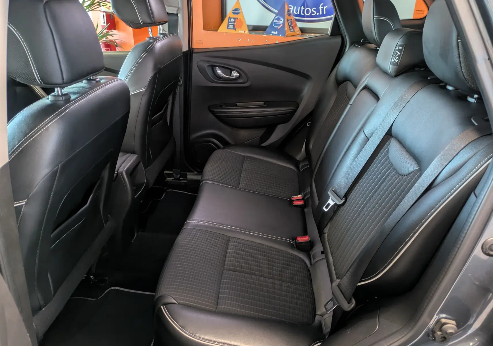 Vue intérieure arrière côté droit montrant les sièges en cuir noir du Renault Kadjar gris 2017.