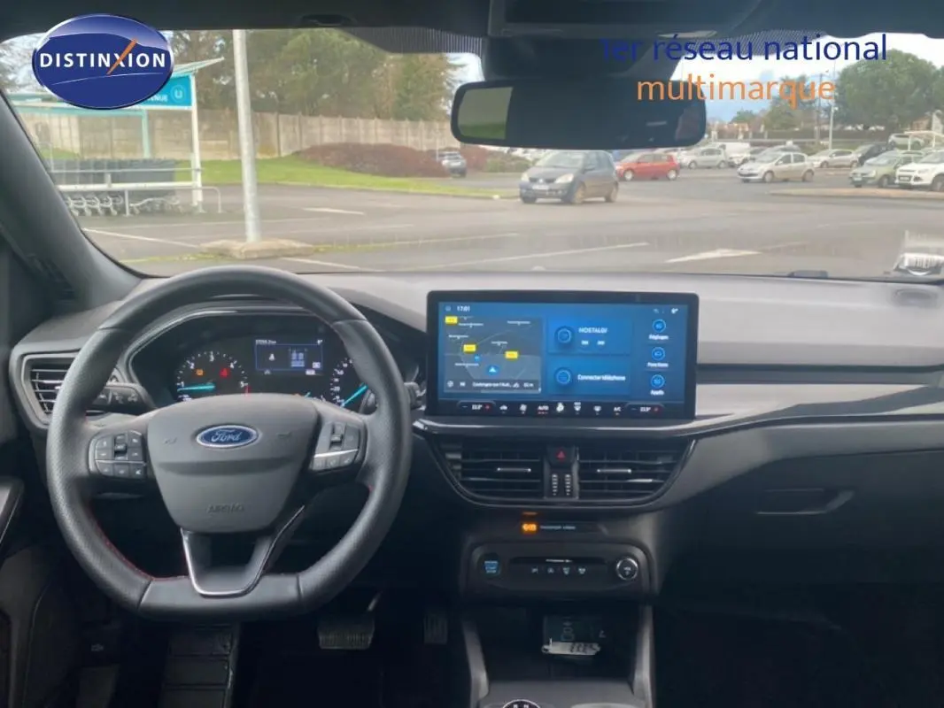 Vue intérieure avant du tableau de bord gris foncé de la Ford Focus 2024 avec écran tactile et volant multifonction.