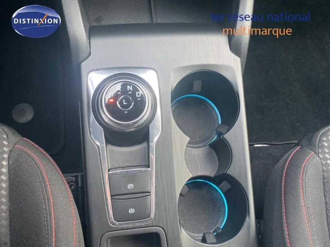 Vue plongeante sur la console centrale grise avec molette de boîte auto et porte-gobelets de la Ford Focus 2024.