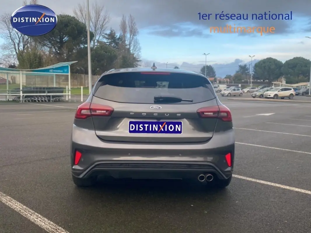 Vue arrière d'une Ford Focus gris foncé 2024 avec feux LED, double sortie d'échappement et vitres surteintées.