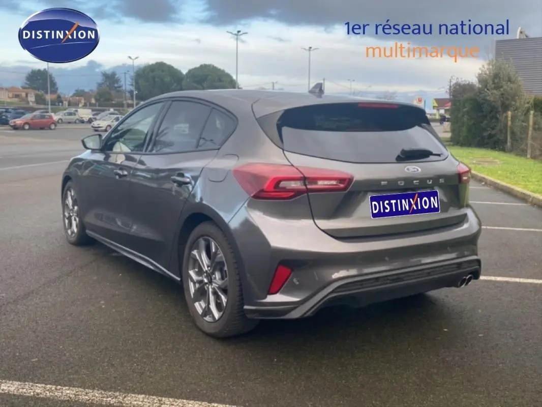 Vue 3/4 arrière droite d'une Ford Focus gris foncé 2024 avec jantes alliage 17 pouces et vitres surteintées.