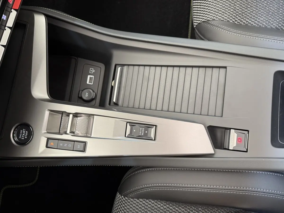 Vue rapprochée de la console centrale gris clair du Peugeot 308 Hybrid 136 e-DCS6 GT avec commandes de boîte auto et bouton start/stop.