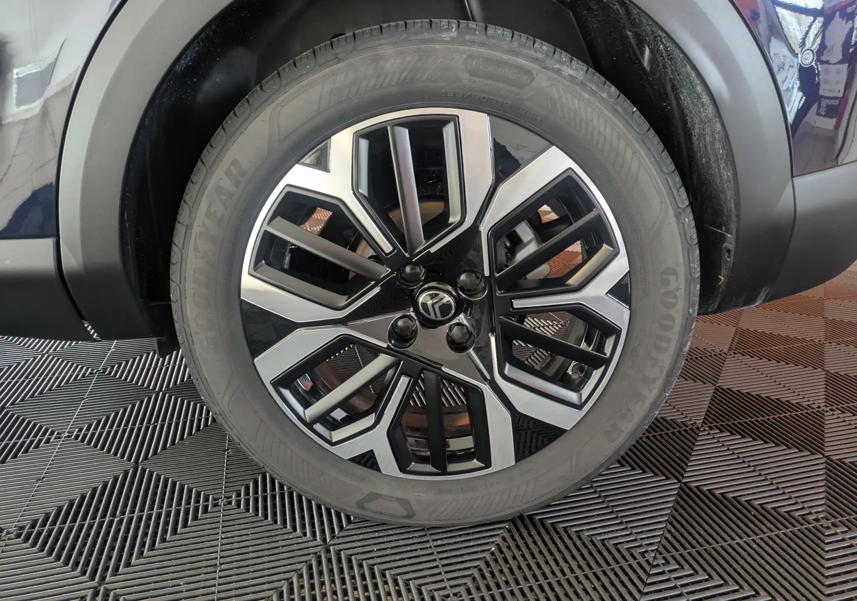 Gros plan sur la jante alliage 18 pouces bicolore noir et argent du côté arrière droit d'une Citroën C4 Bleu Eclipse.