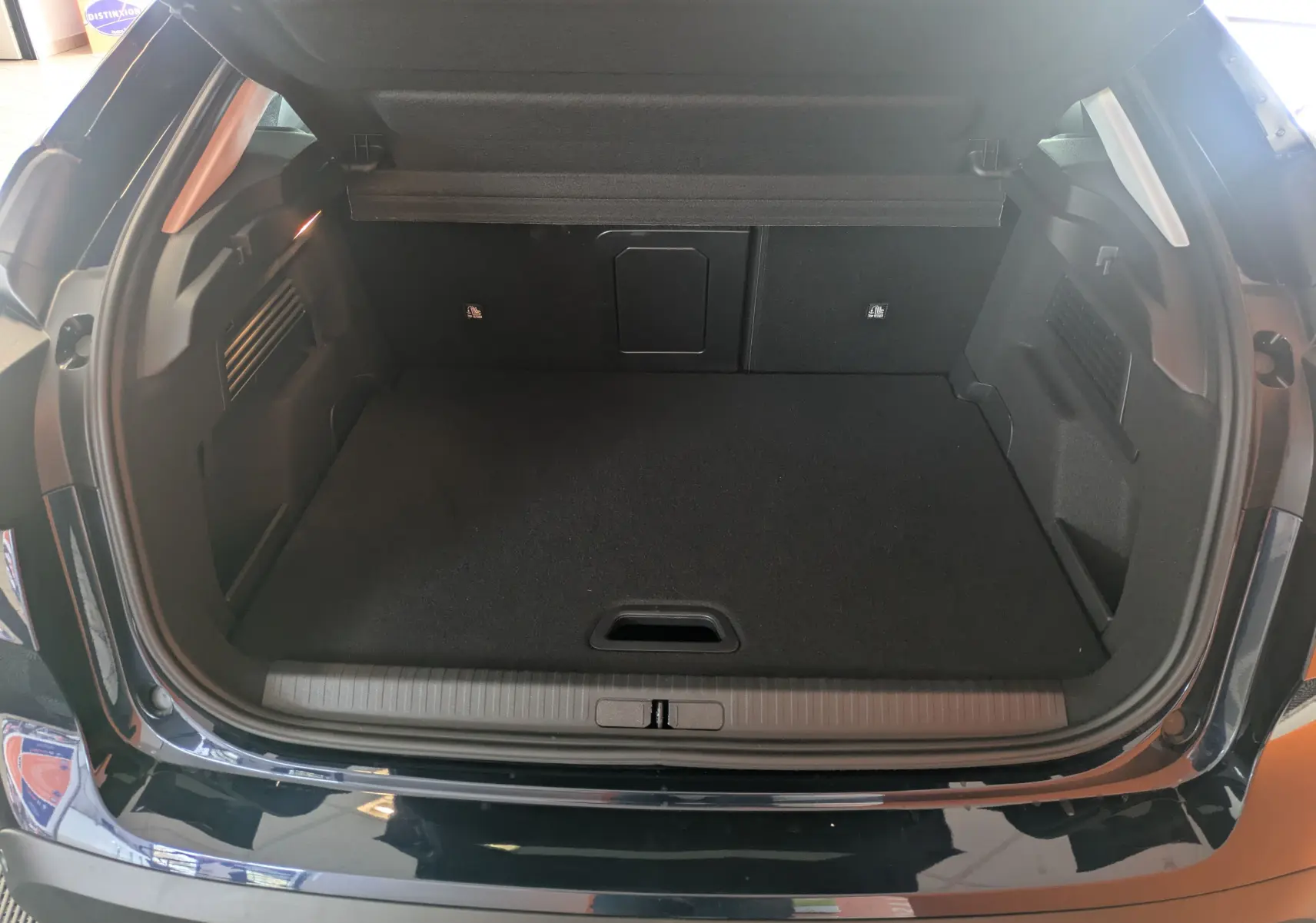 Coffre ouvert vu de l'arrière d'une Citroën C4 hybride bleu Eclipse avec intérieur noir et plancher plat.