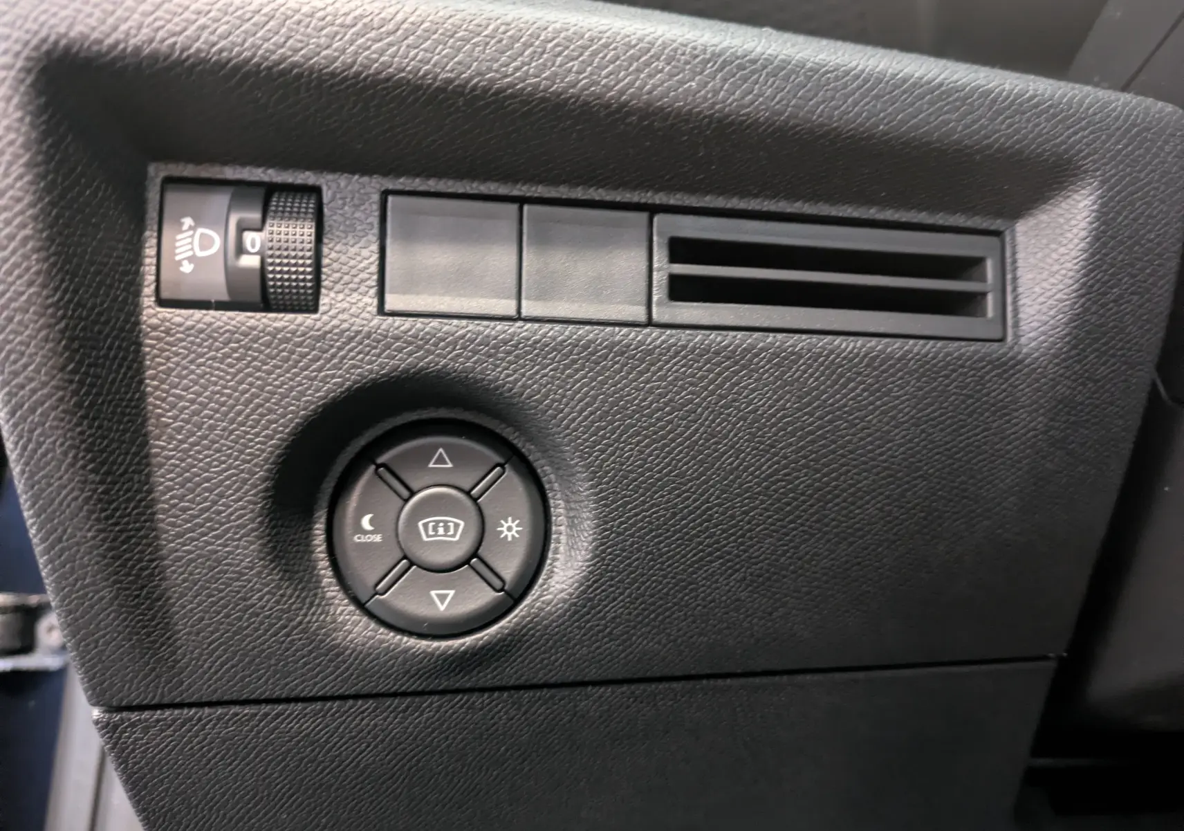 Détail du tableau de bord noir côté gauche avec commandes d’éclairage et ventilation, Citroën C4 Hybride 2025 bleu Eclipse.