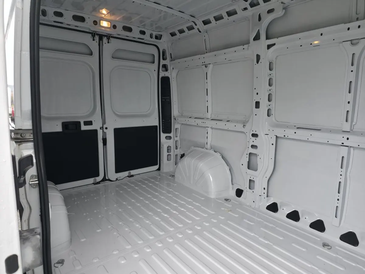 Vue intérieure arrière du Peugeot Boxer Fourgon blanc montrant l'espace de chargement tôlé et vide.