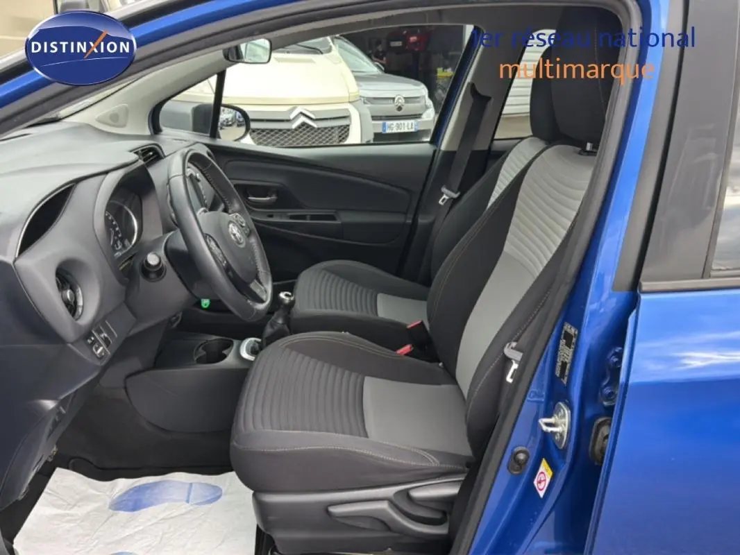 Intérieur de la Toyota Yaris MC2 bleu foncé vu côté conducteur, avec sièges tissu bicolore et volant multifonctions.
