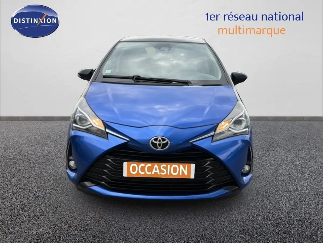 Vue avant d'une Toyota Yaris bleu foncé 2018 avec calandre noire et phares allumés, plaque "OCCASION" visible.