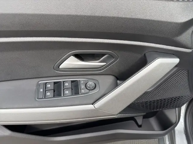 Détail de la porte côté conducteur du Dacia Bigster gris foncé, avec commandes électriques des vitres et poignée intégrée.