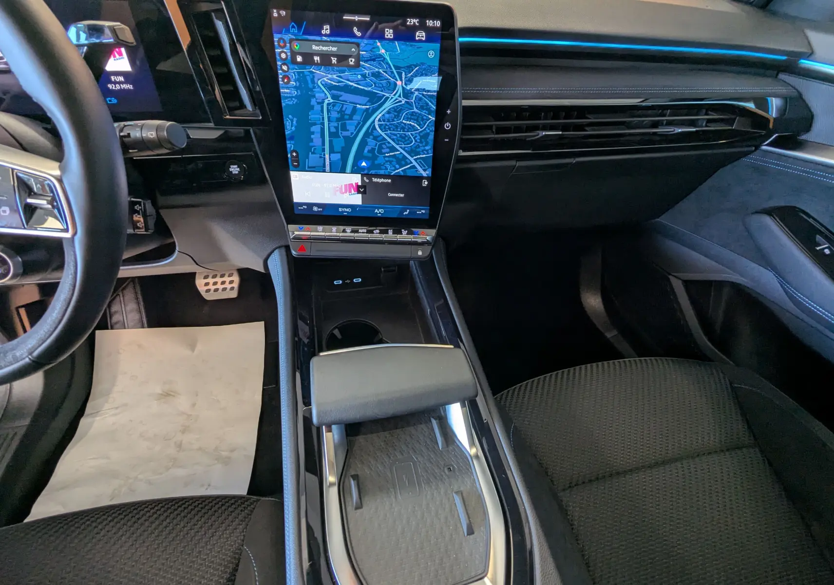 Vue intérieure du tableau de bord et console centrale du Renault Espace VI E-Tech noir étoile avec écran tactile vertical et sièges en tissu noir.