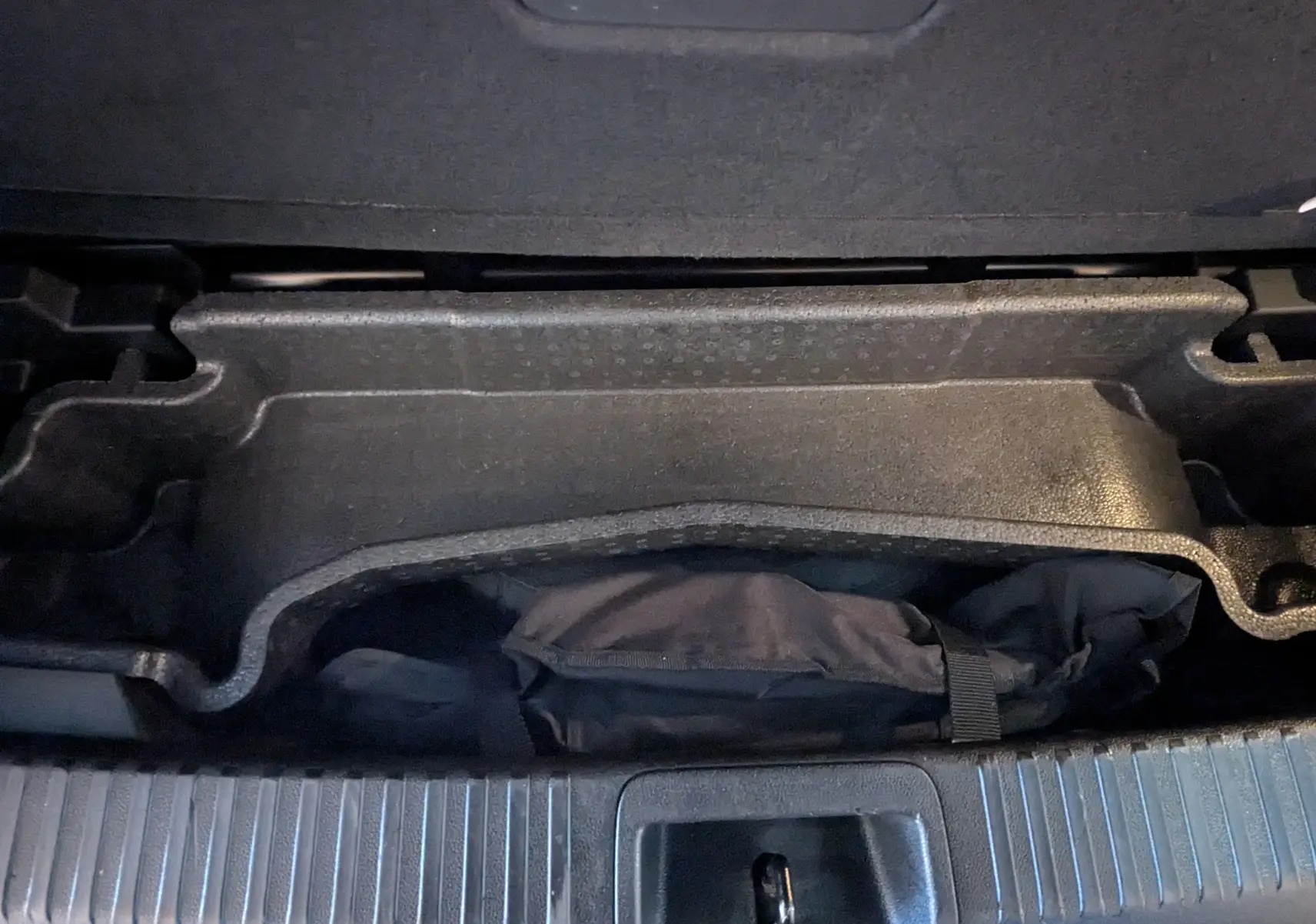 Coffre ouvert du Renault Espace VI noir Étoile, montrant le rangement sous plancher avec sac de secours.