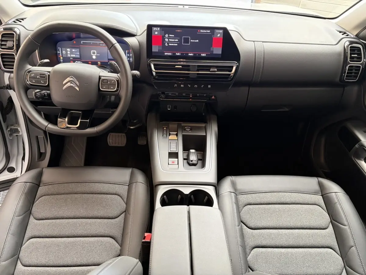 Intérieur du Citroën C5 Aircross 2025, vue avant centrée sur tableau de bord et volant multifonctions cuir noir.