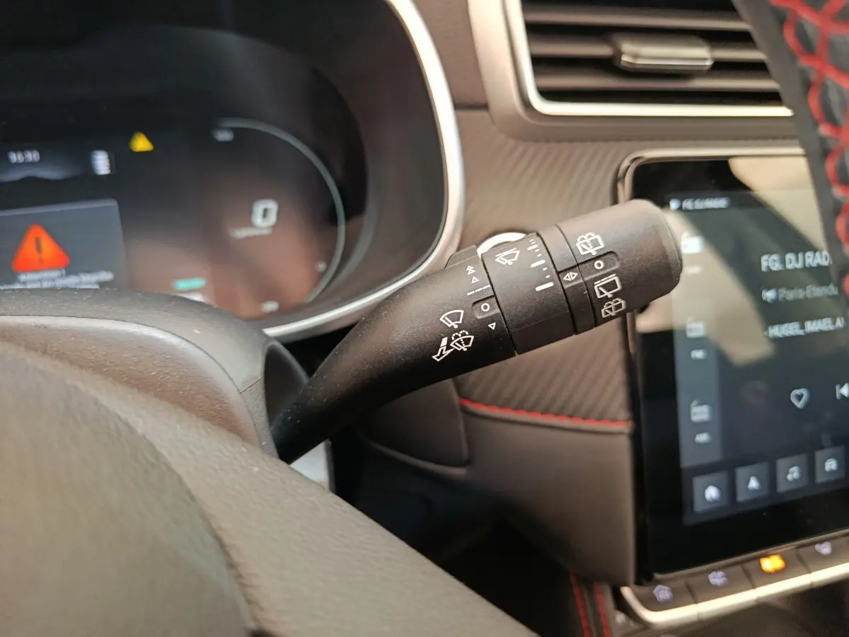 Gros plan sur la commande des essuie-glaces du MG Motor ZS Luxury noir, avec tableau de bord et écran tactile visibles.