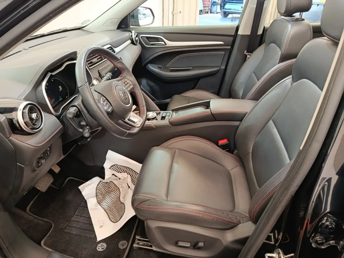 Intérieur noir du MG ZS Luxury 2024 vu côté conducteur, avec sièges cuir et volant multifonctions.