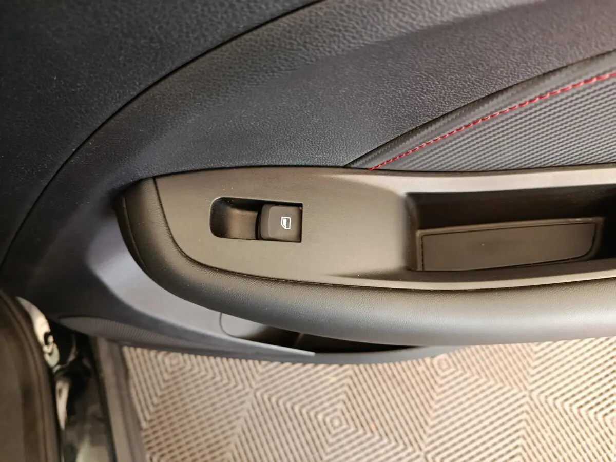 Détail de la commande de lève-vitre sur la porte côté conducteur d’un MG Motor ZS Luxury noir 2024.
